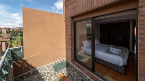 A modern hotel room with a large sliding glass door leading to a balcony with a view of the city. - Spectacular 4BR @Financial and Commercial Zone (Bogotá)