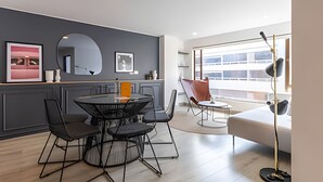 A modern living room with a round dining table, black chairs, a sofa, and a floor lamp. - Relaxing 3BR @Commercial Area near Zona G (Bogotá)