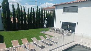 Zona junto a la piscina con sillones de descanso y terraza.