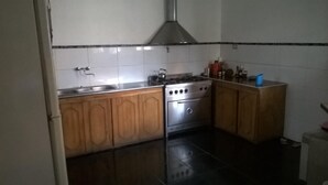 A kitchen with wooden cabinets, a stainless steel stove, and a sink. - Hostel Casa la Red (Mar del Plata)