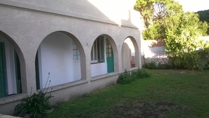 A building with a series of arched windows and a green door. - Hostel Casa la Red (Mar del Plata)