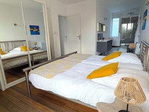 A bedroom with a bed, a bedside table, a lamp, and a mirror.