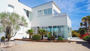 A modern two-story house with large windows and a balcony.