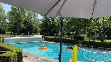 Una piscina al aire libre, una piscina climatizada