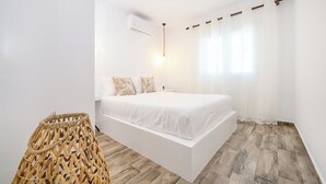 A modern bedroom with a hanging bed, white walls, and a wooden floor. - Azure Horizon Skyros (Aspous)