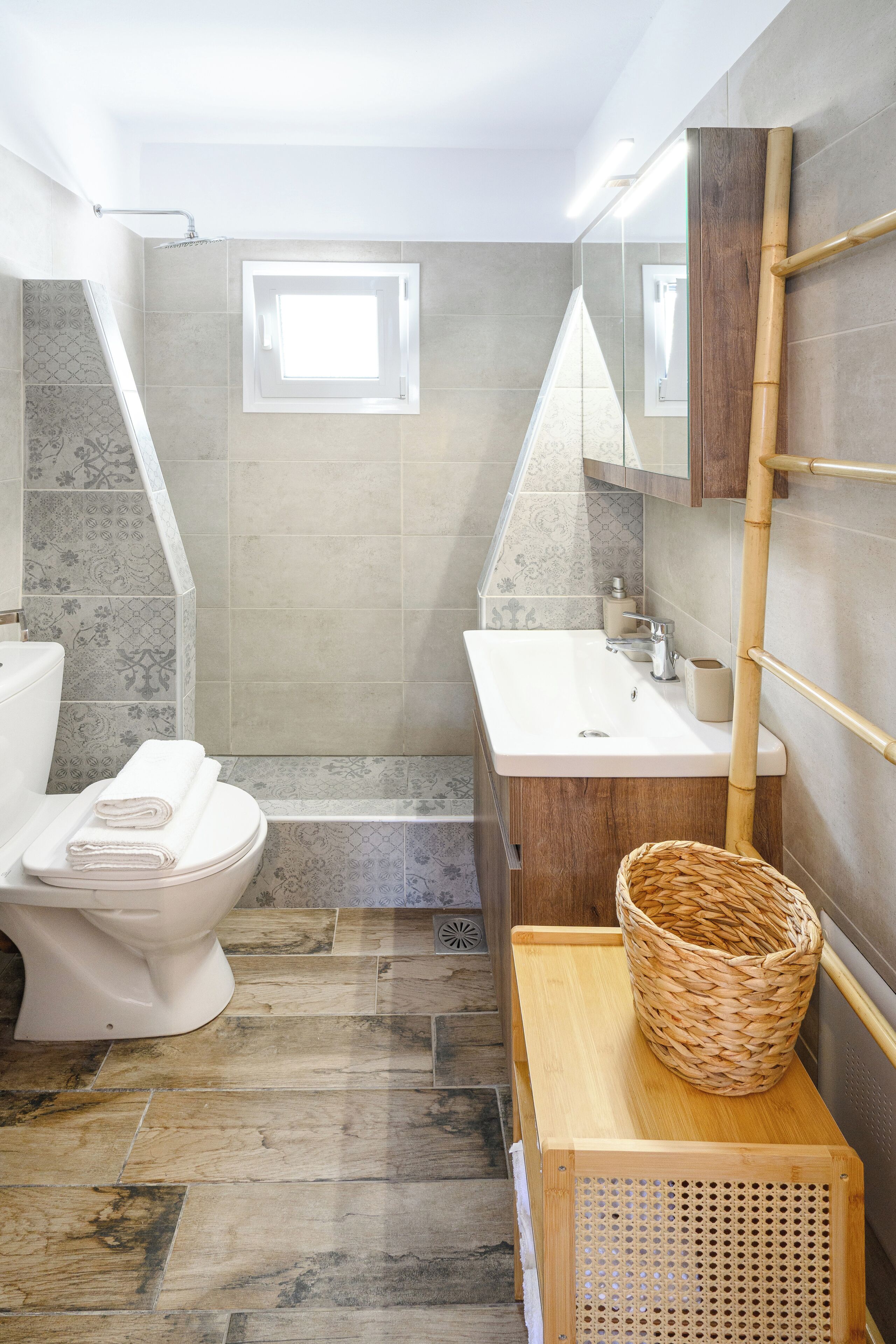 Et badeværelse med toilet, vask og bruseområde.