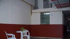 A room with a red and white wall, a small white table with two chairs, and a potted plant on the table. - Alma Bohemia Hostel (Buenos Aires)