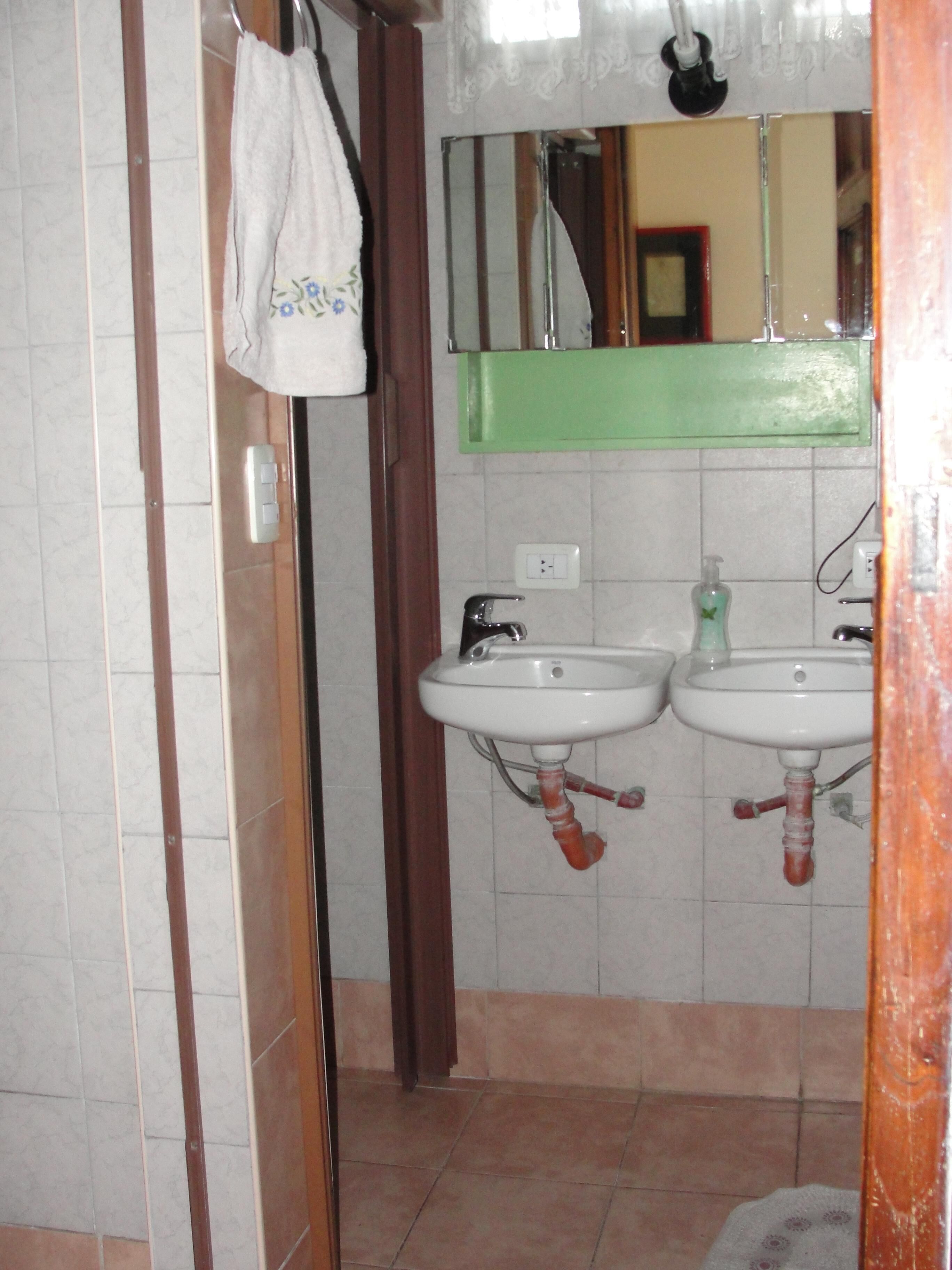A bathroom with two sinks, a mirror, and a towel hanging on a rack.