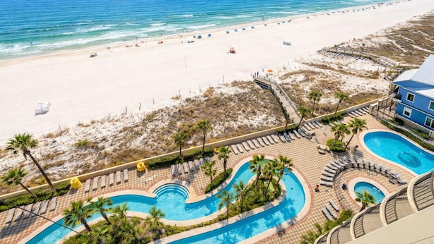A resort with a beach view, a pool area, and a building with balconies. - Spacious Beachfront Comfort  Phoenix West 1005 (Orange Beach)