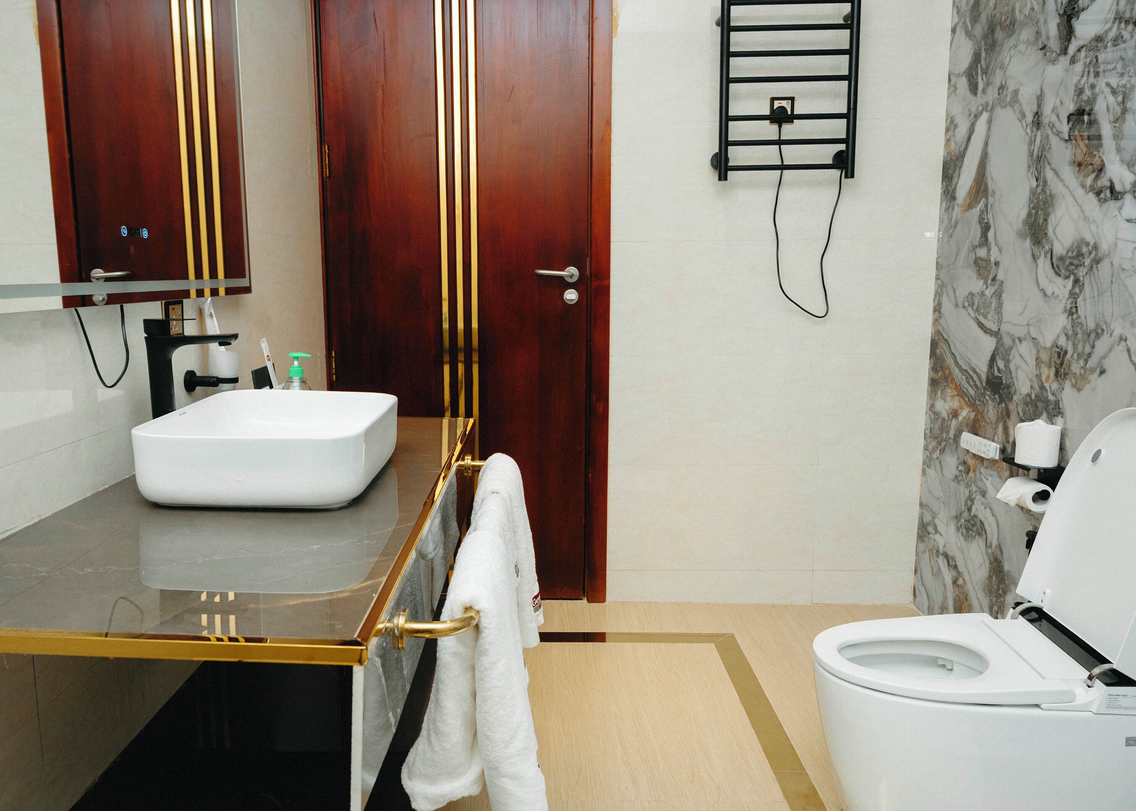 A modern bathroom with a white sink, a toilet, and a mirror above the sink.