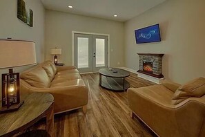 A living room with a sofa, coffee table, and fireplace.