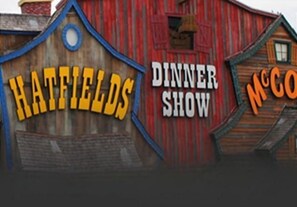 A wooden building with signs reading "Hatfields" and "Dinner Show".