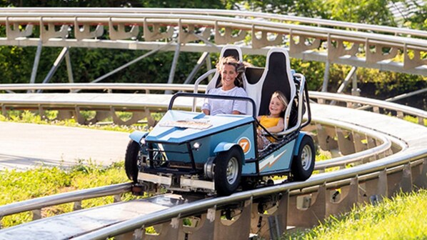 A roller coaster with a blue car and passengers.
