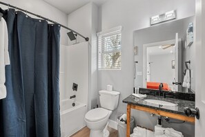 A modern bathroom with a bathtub, toilet, and sink. - Cozy Studio for 2 | Minutes from Dollywood in Sevierville (Sevierville)