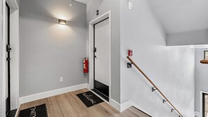 A hallway with a fire extinguisher, a welcome mat, and a handrail. - Cozy Studio for 2 | Minutes from Dollywood in Sevierville (Sevierville)