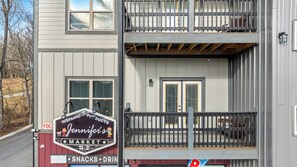 Un bâtiment à deux étages doté d’un balcon, d’une enseigne indiquant « Jennifer’s Market », et une vue de la rue.