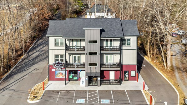 A multi-story building with a commercial ground floor featuring a sign for Jennifer's Gourmet.