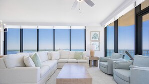 Ein geräumiges Wohnzimmer mit einer großen Eckcouch, einem Couchtisch und Blick auf den Ozean.