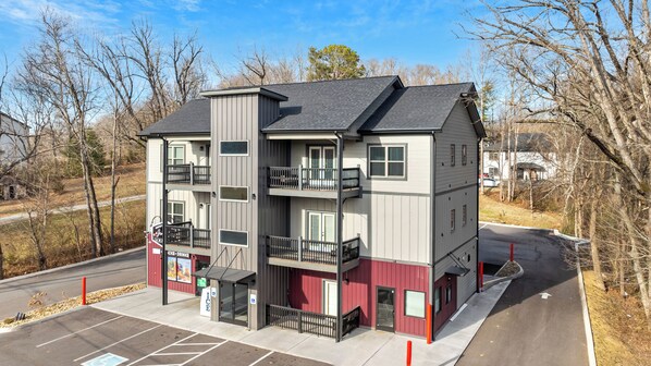 A multi-story building with a parking lot in front.