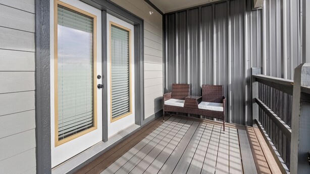 A covered porch with two doors, a bench, and a railing. - Studio Condo in Sevierville| King Bed| Sleeps 2 + Dollywood Ticket (Sevierville)