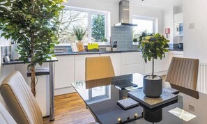 Une cuisine moderne avec une table à manger, des chaises et des plantes en pot.