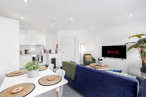 A modern apartment with a kitchen, dining area, and living room.