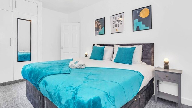 A modern bedroom with a large bed, a bedside table, a wardrobe, and a door. - The No.7 | Modern 3BR House | Pool Table Pingpong (Brampton)