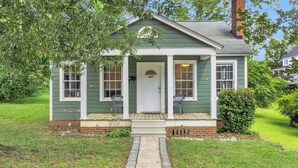 A small, single-story house with a front porch, a chimney, and a mailbox.