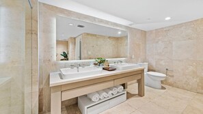 A modern bathroom with two sinks, a large mirror, and a toilet. - Luxury Vacation Rentals at 1 Hotel & Homes by LRMB (Miami Beach)