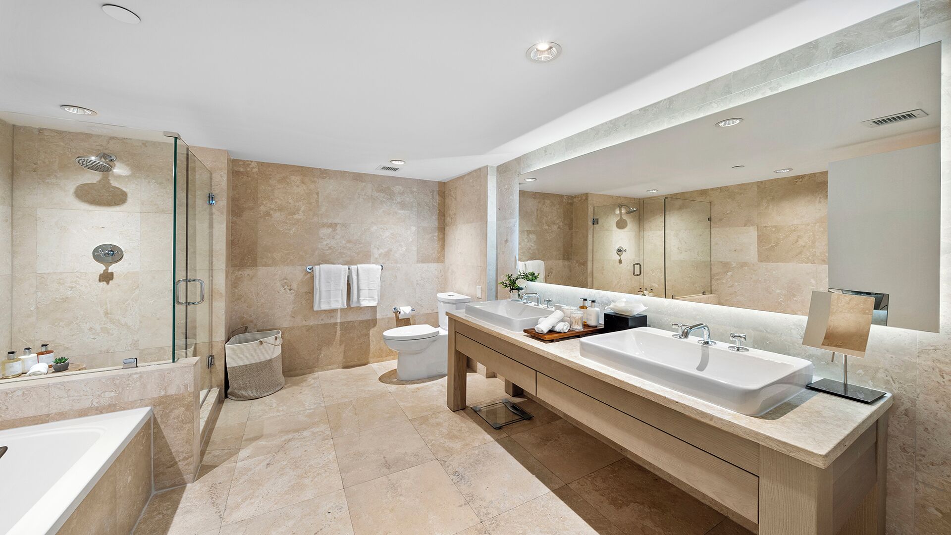 A modern bathroom with a glass-enclosed shower, a double sink vanity, and a large mirror.