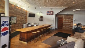 Eine moderne Küche mit einer Holztheke, Barhocker und einem Kühlschrank mit Diet Pepsi Schriftzug.