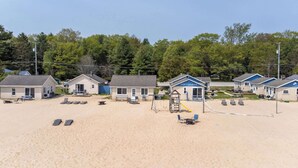 Strandhütten mit Sitzgelegenheiten im Freien und einem Volleyballnetz.