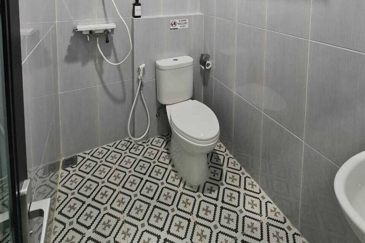 Un baño pequeño con inodoro, ducha y lavabo.