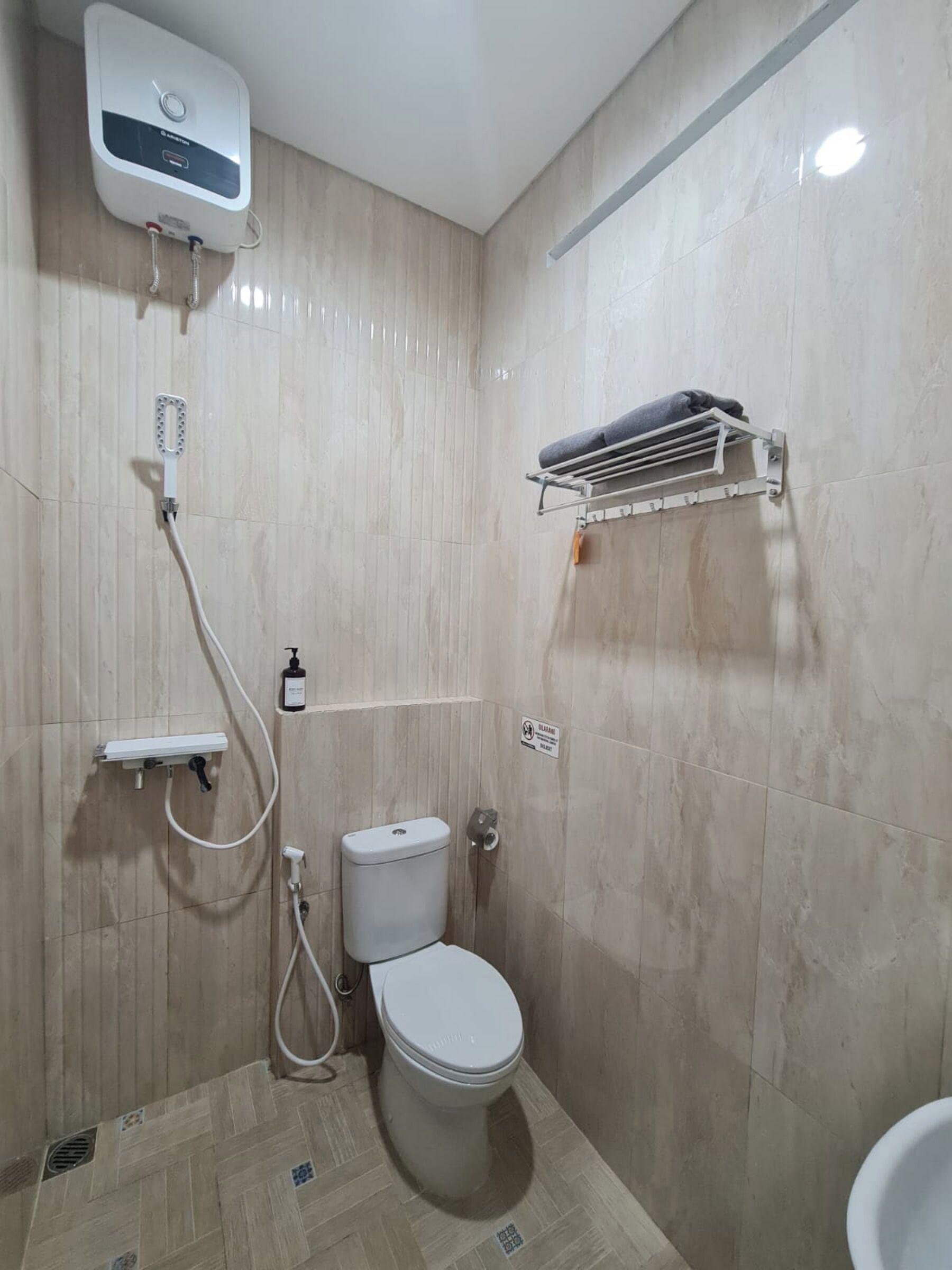 Ein Badezimmer mit Toilette, Duschkabine und Handtuchhalter.