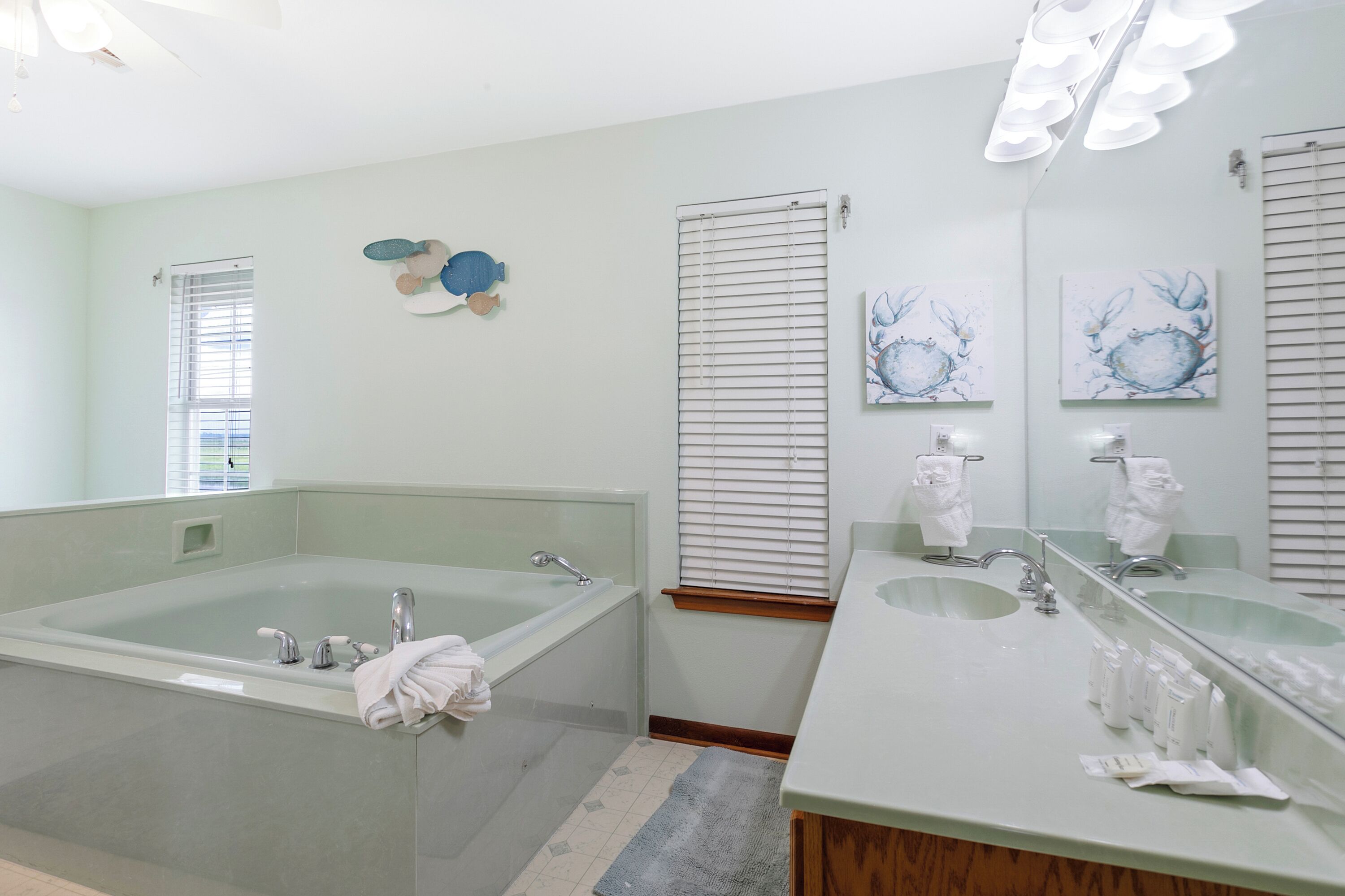 A modern bathroom with a large bathtub, two sinks, and a vanity.