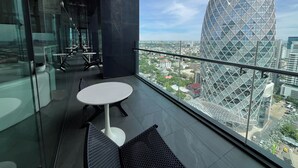 A modern interior with a glass wall, a round table, and a view of a unique building.