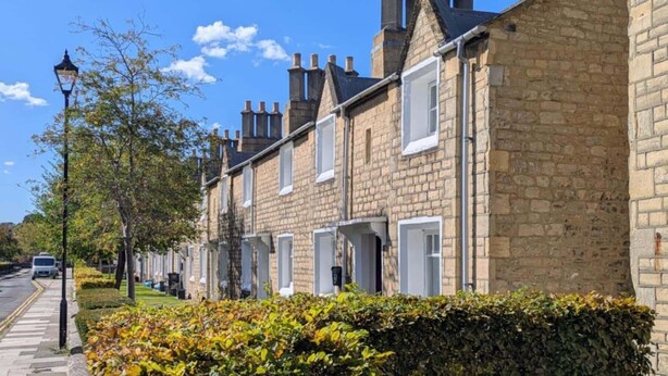 A row of terraced houses with brick facades, white window frames, and multiple chimneys. - 1840's Converted Railway Cottage (Swindon)