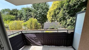A balcony with a view of trees and a building. - Bright and Spacious 3-Bedroom Apartment - Direct Access to Central Paris (Choisy-le-Roi)