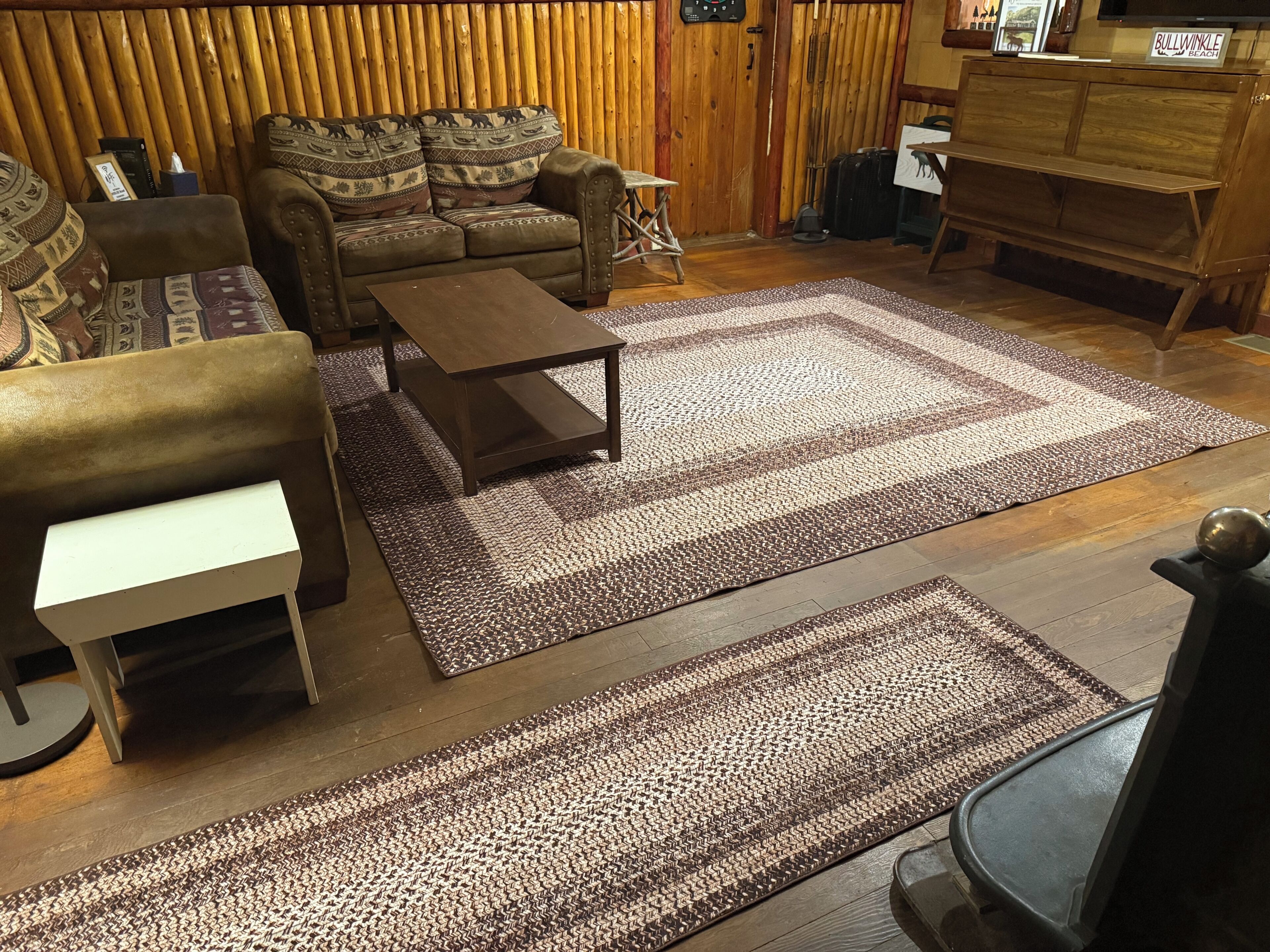A living room with a sofa, a coffee table, and a patterned rug.