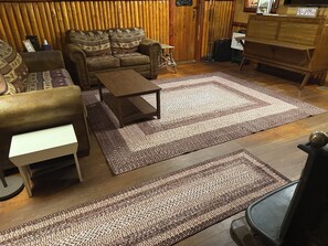 Un salon avec un canapé, une table basse et un tapis à motifs.
