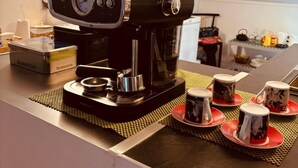 Een keuken met een koffiezetapparaat, een doos met de tekst 'Normandie' en een paar mokken op het aanrecht.