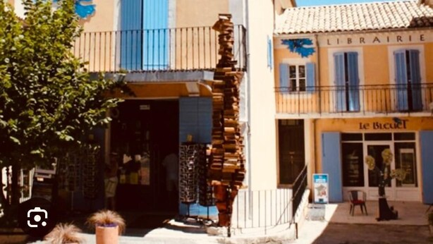 Een gebouw met de tekst 'LIBRAIRIE' en 'Le Bledet', dat een boekwinkel of bibliotheek aanduidt.