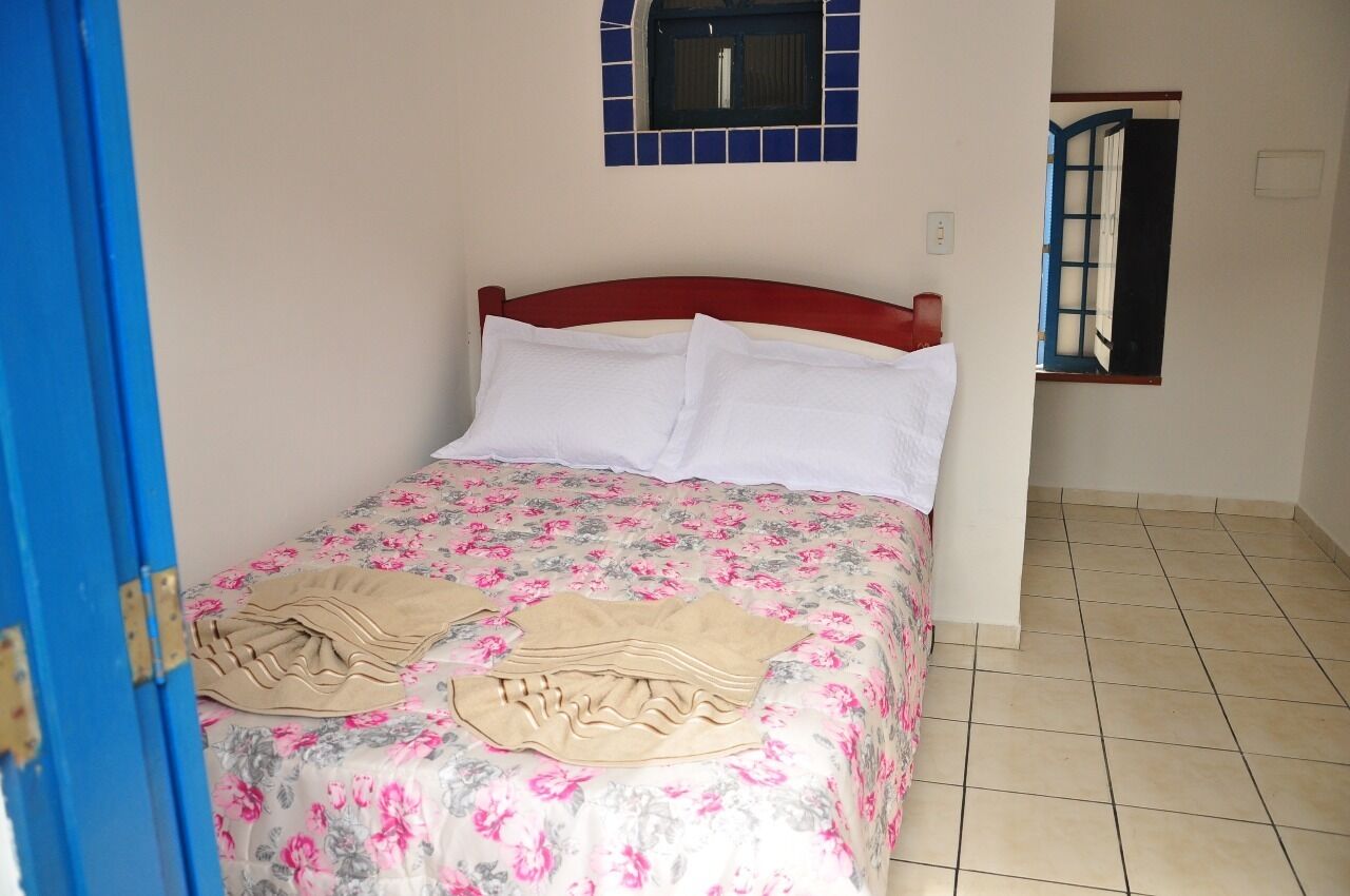 A bedroom with a bed, a window, and a door.