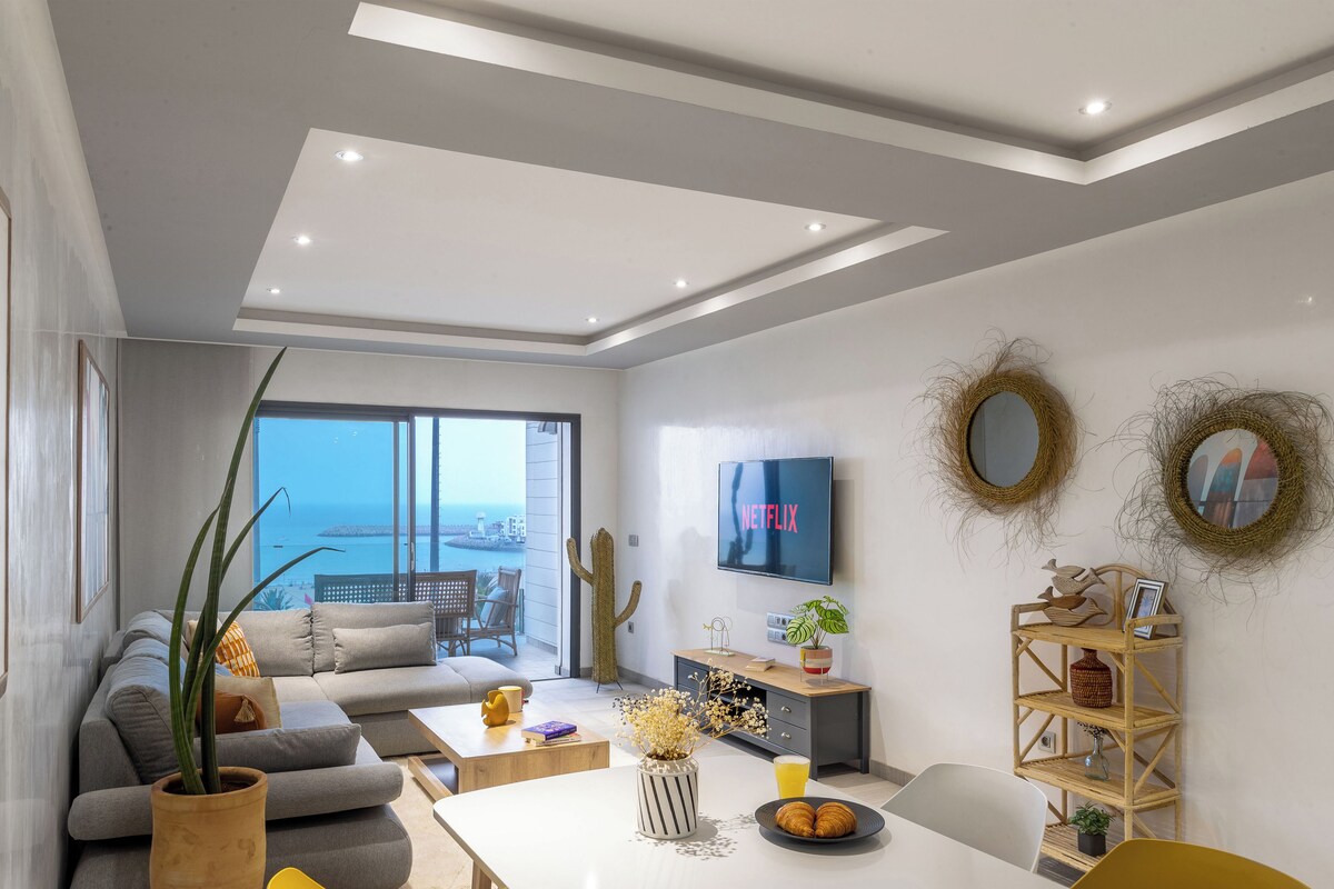 Un salon moderne avec un canapé, une table basse et un téléviseur fixé au mur.