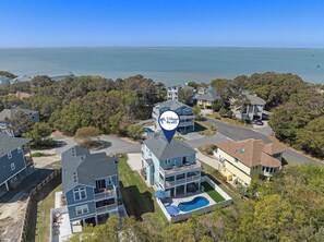Un quartier résidentiel avec des maisons, une piscine et une jetée qui s’avance dans l’eau.