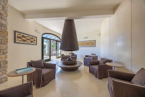 Eine moderne Lounge mit Sofas, einem Couchtisch und einem Kamin.