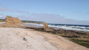 A rocky beach with large boulders and a clear view of the ocean. - Crannoch Self Catering (Buckie)