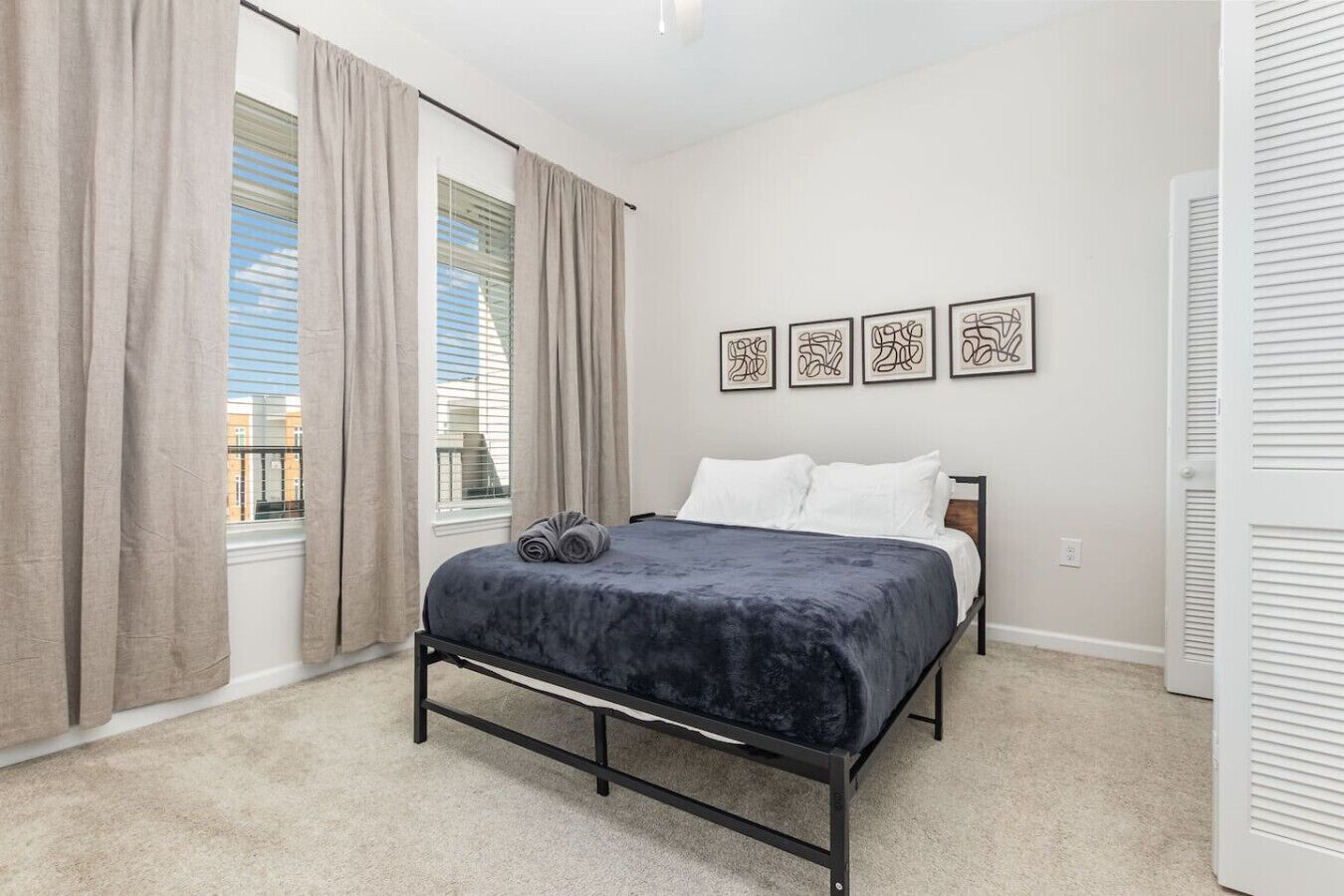 Un dormitorio con cama, cortinas, una ventana y decoración en la pared.