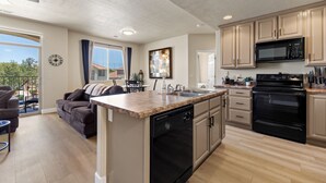 A modern kitchen with a central island, built-in microwave, and oven. - Par Paradise by Mesquite Vacation Rentals with Views of the Fairways and $510 in free daily activities (Mesquite)