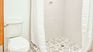 A bathroom with a shower, toilet, and a window. - Hotel Villa Santa Maria  (Santa Fe de Antioquia)